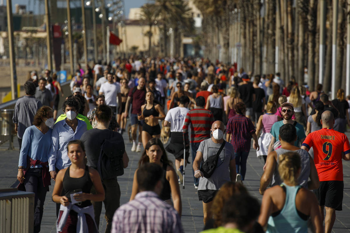 People exercise on a seafront promenade in this photo taken with a telephoto lens in Barcelona, ...