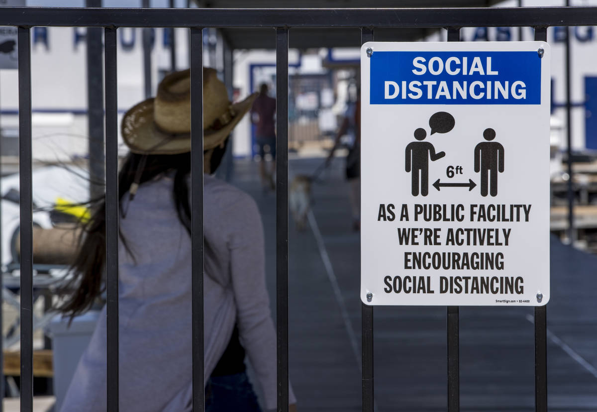 A social distancing sign greets visitors at the Las Vegas Boat Harbor in the Lake Mead National ...