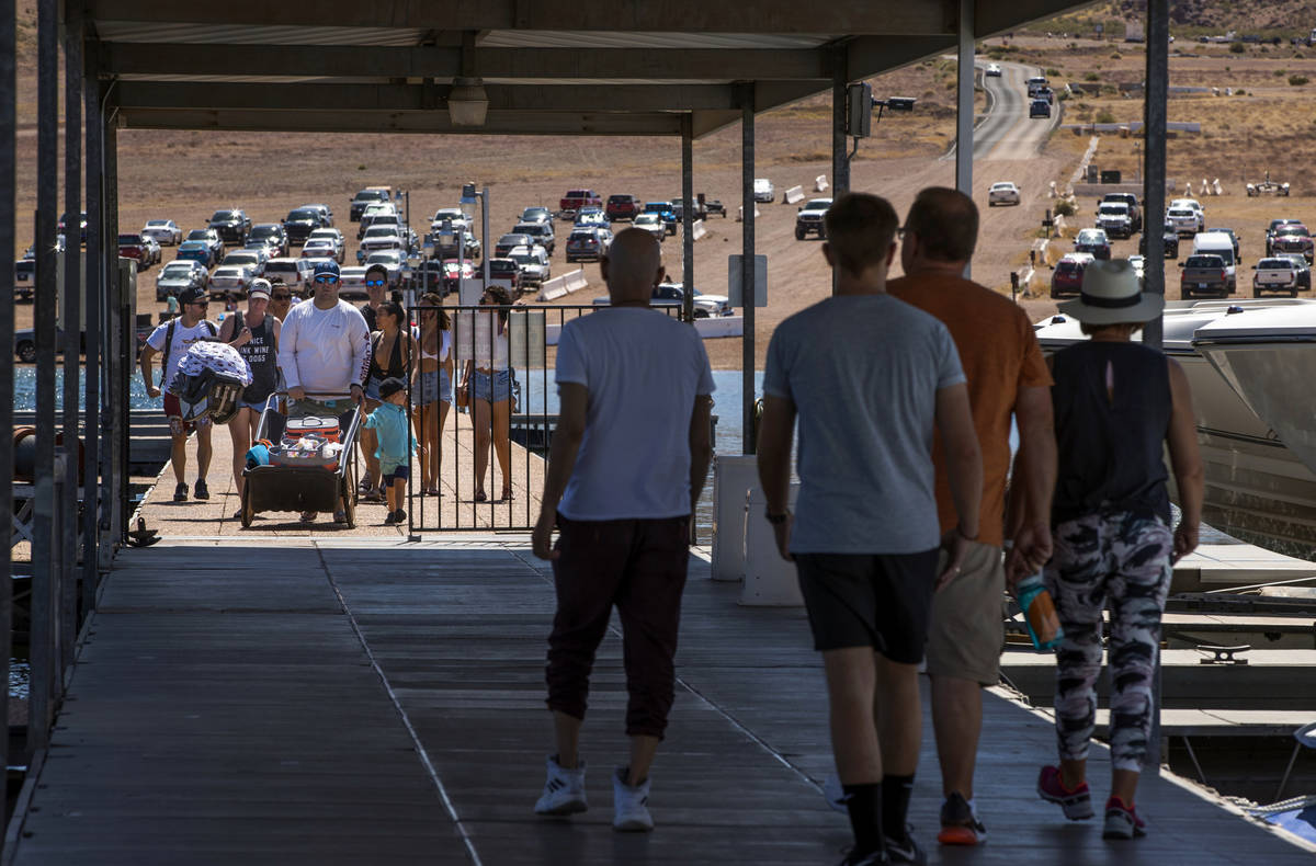 Visitors walk on the pier at the Las Vegas Boat Harbor in the Lake Mead National Recreation Are ...