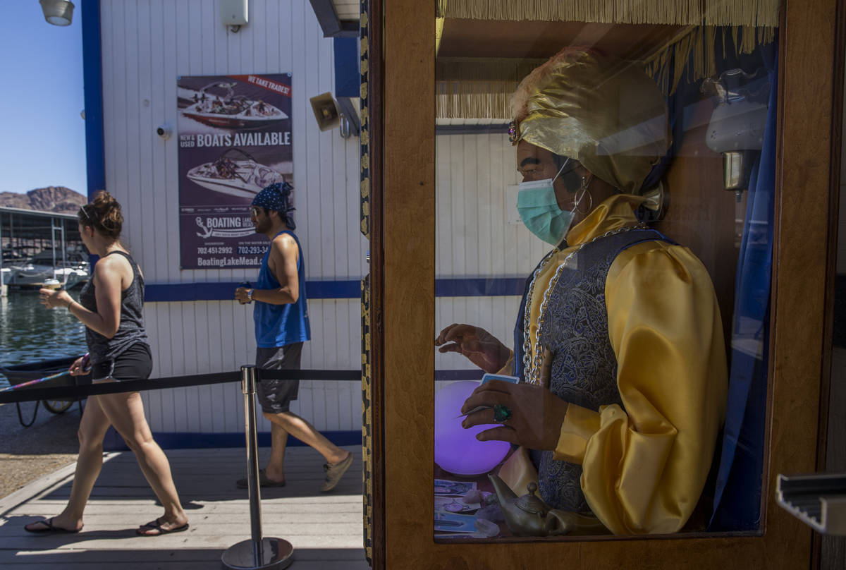 A Zoltar Fortune Teller machine with face mask with visitors at the Las Vegas Boat Harbor in th ...