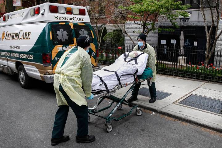 A patient is loaded into the back of an ambulance by emergency medical workers outside Cobble H ...