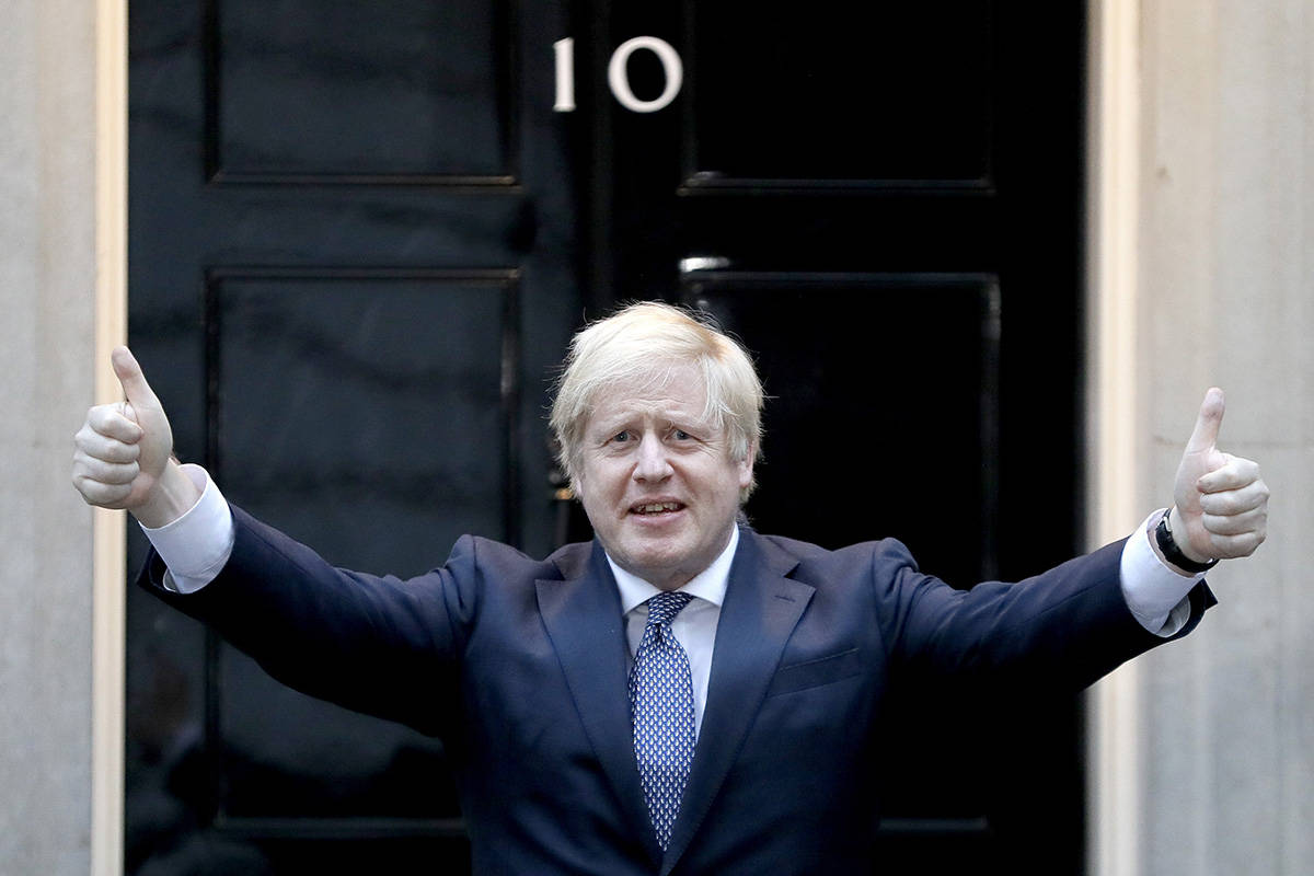 Britain's Prime Minister Boris Johnson shows thumbs up before he applauds on the doorstep of 10 ...