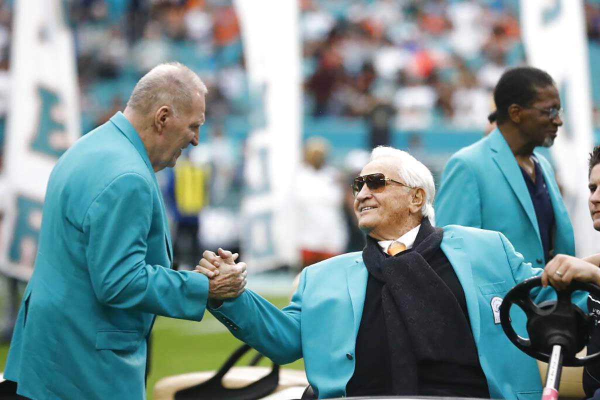 Former Miami Dolphins head coach Don Shula, right, is greeted on the field by former players du ...