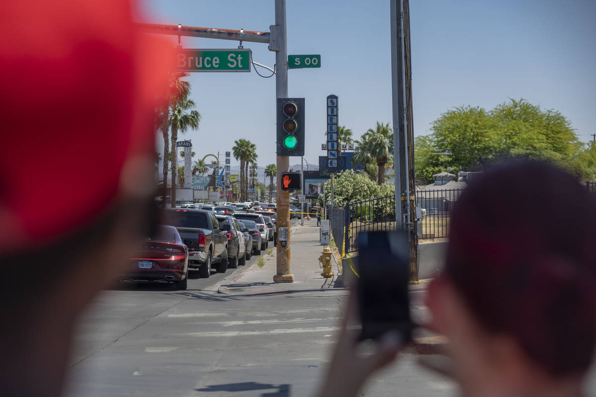 Individuals watch as the Las Vegas police investigate a downtown shooting in the 1900 block of ...