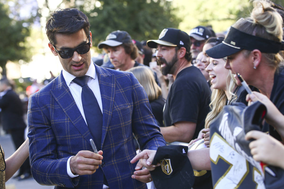 Golden Knights' Max Pacioretty signs autographs on the gold carpet after arriving for the NHL s ...