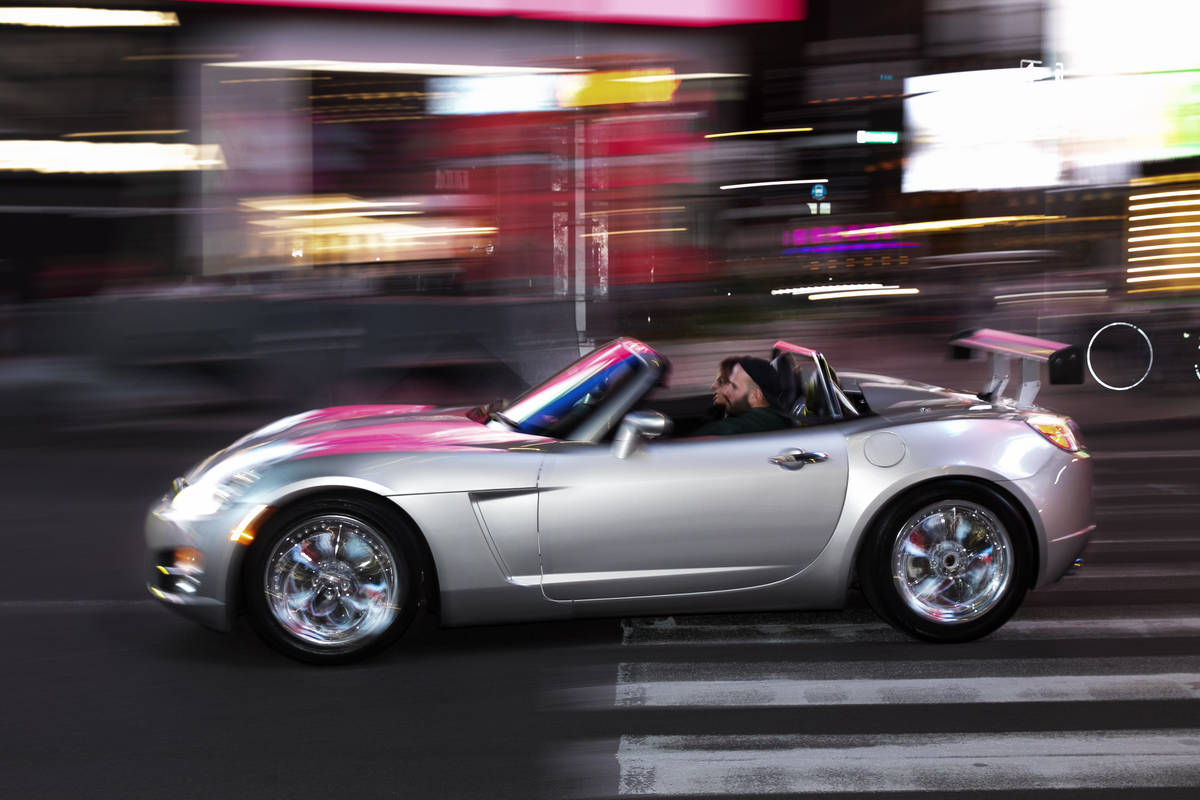 In this Saturday, May 2, 2020 photo, a man drives his convertible sports car through New York's ...