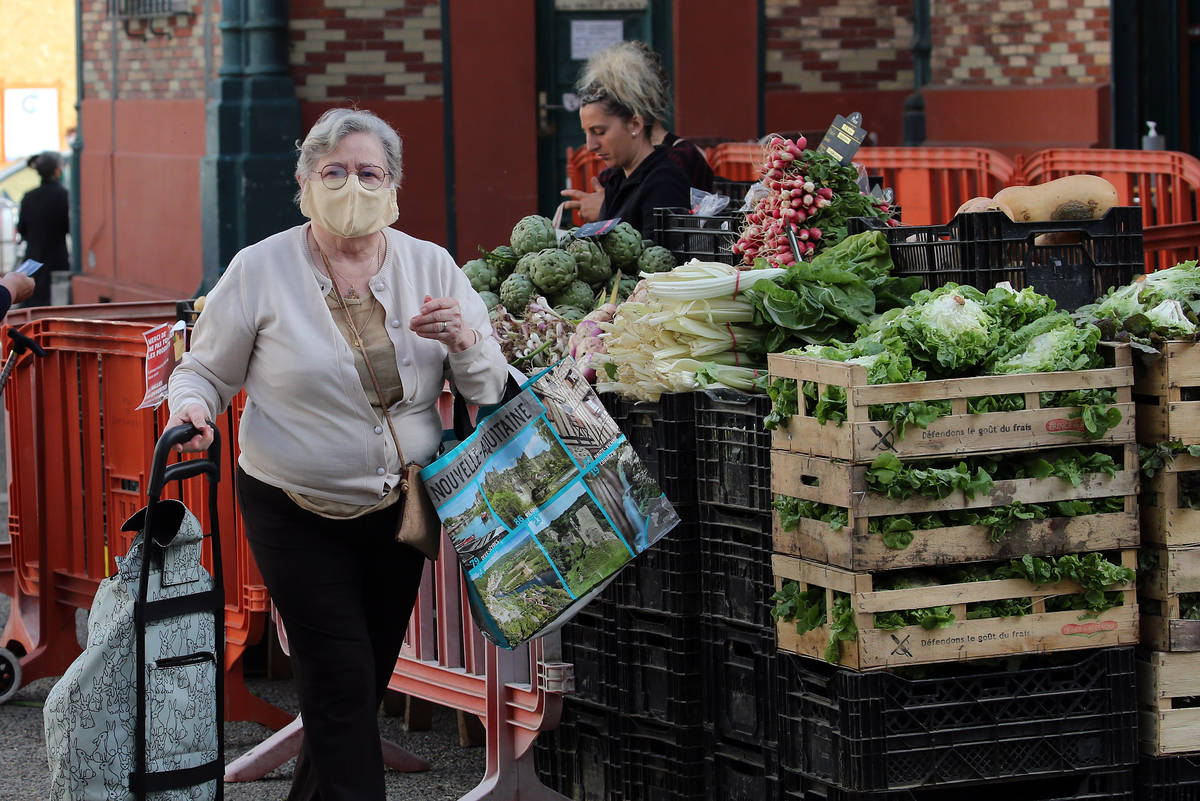 A woman shops at an open air market which reopened today in Saint Jean de Luz, southwestern Fra ...