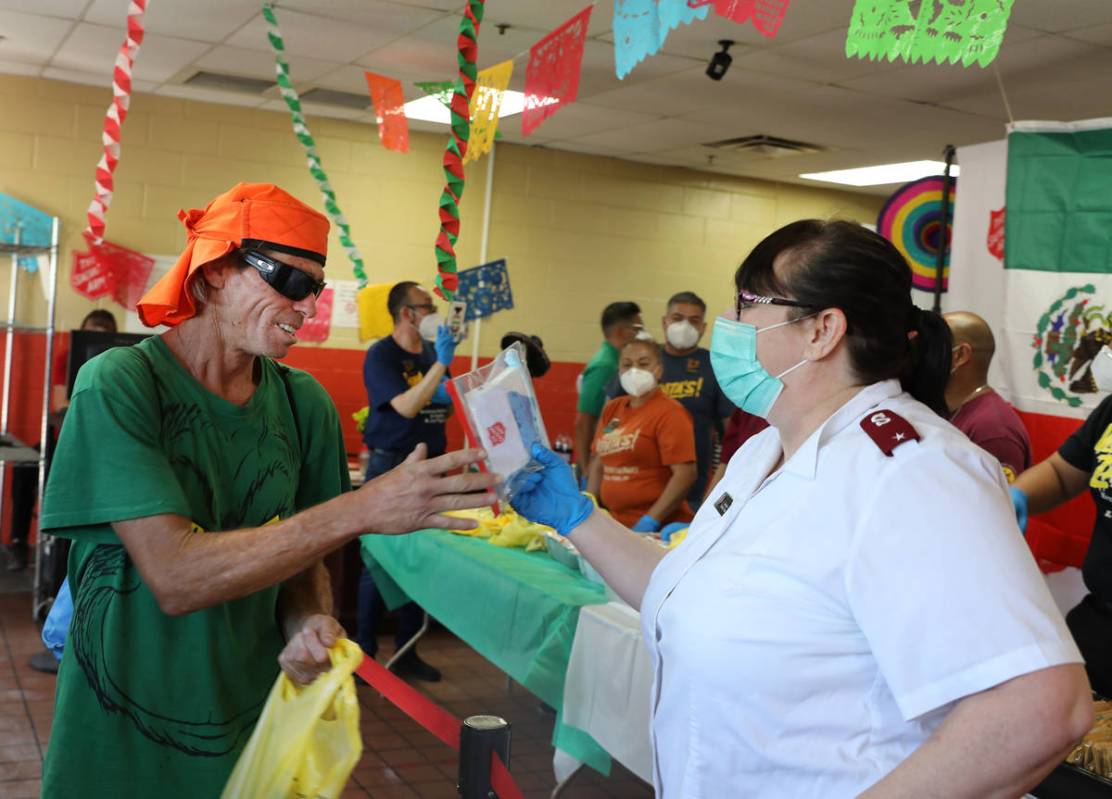 The Salvation Army Lieutenant Heather Baze hands out a pandemic kit to ÒWill,Ó left, during a ...