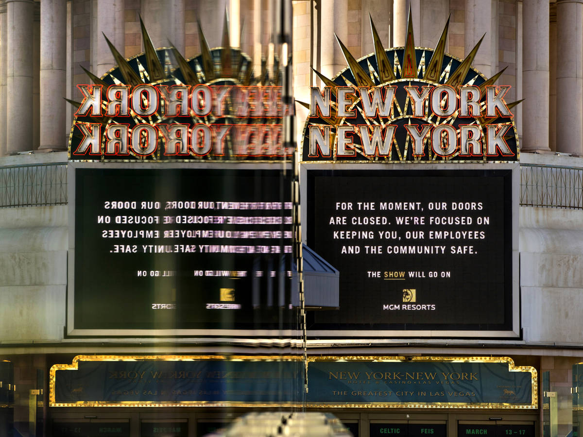 A New-York New-York sign is reflected in pedestrian bridge glass along Las Vegas Boulevard on t ...