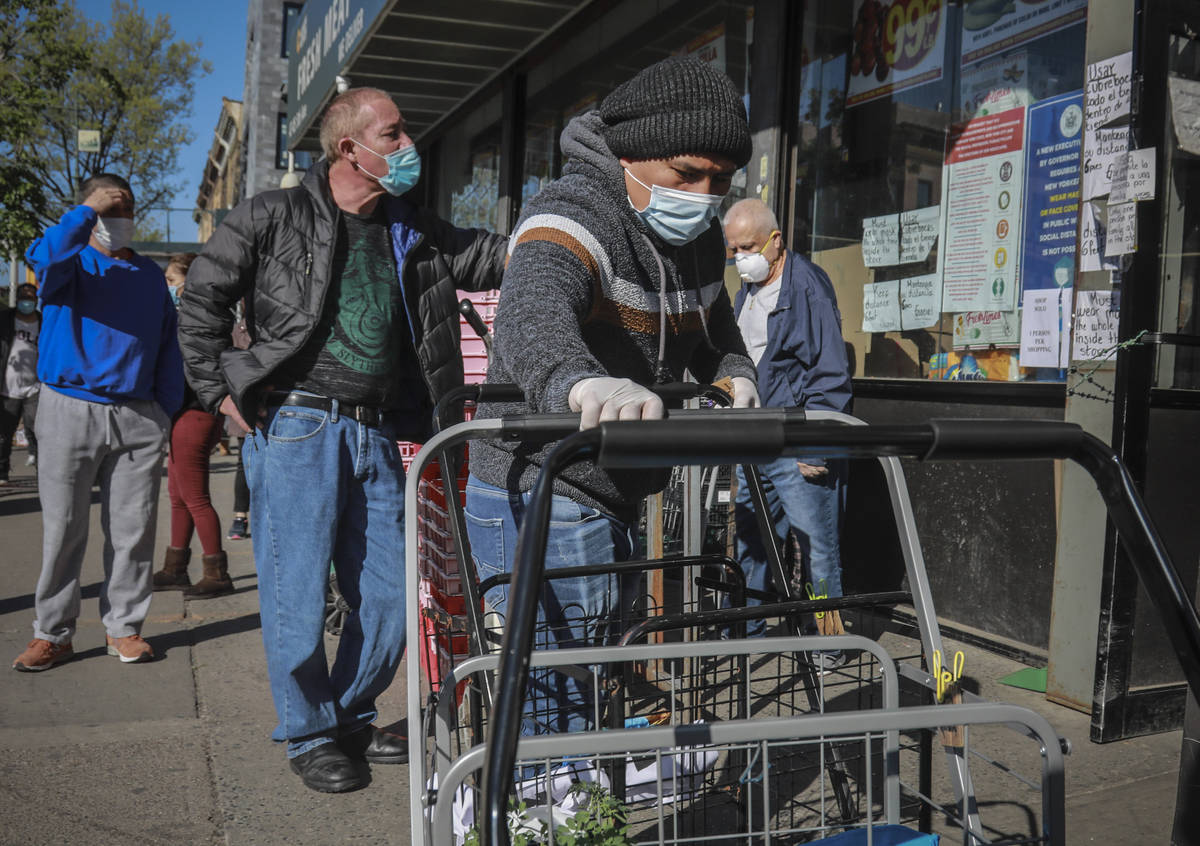 A masked grocery store worker in Brooklyn's Sunset Park—a neighborhood with one of the c ...