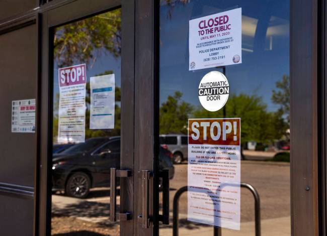 A variety of warning signs posted on the front of the Kingman Police Department during the coro ...