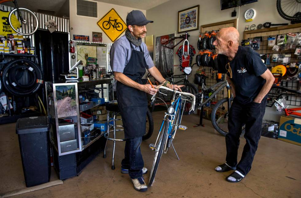 SpokesMann bicycle shop owner Ed Mann, left, talks about the repairs recommended to customer Ma ...
