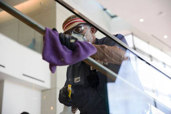 Custodian Jarrell Siler sanitizes handrails in the Hospitality Hall at UNLV in Las Vegas, Thurs ...