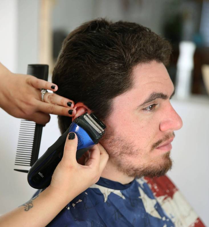 Brittany Seitz, a cosmetologist, cuts her husband's, Michael, hair as she demonstrates how to c ...