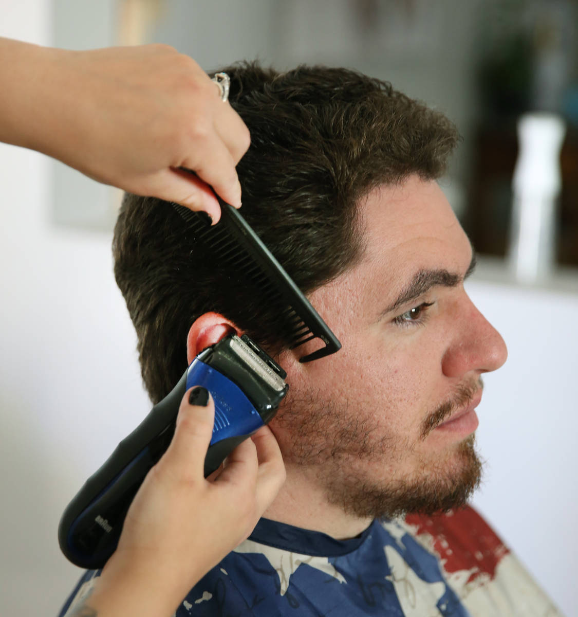 Brittany Seitz, a cosmetologist, cuts her husband's, Michael, hair as she demonstrates how to c ...