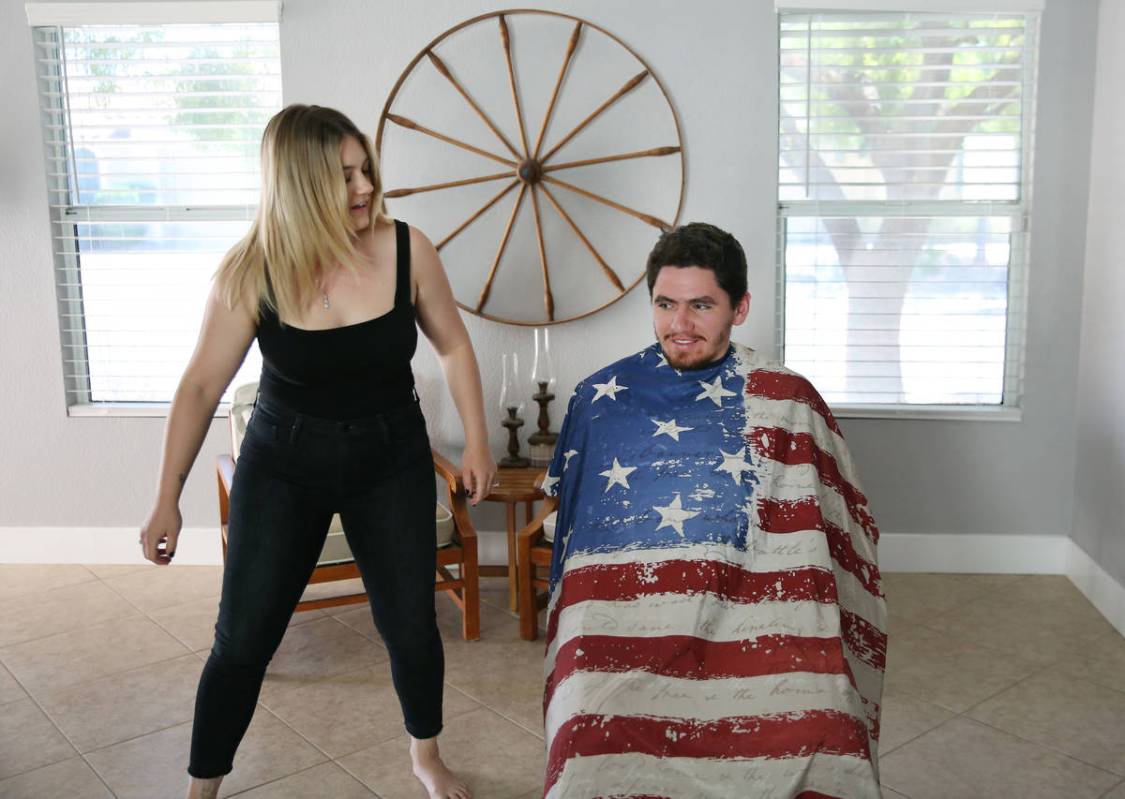 Brittany Seitz, a cosmetologist, prepares to cut her husband's, Michael, hair as she demonstrat ...