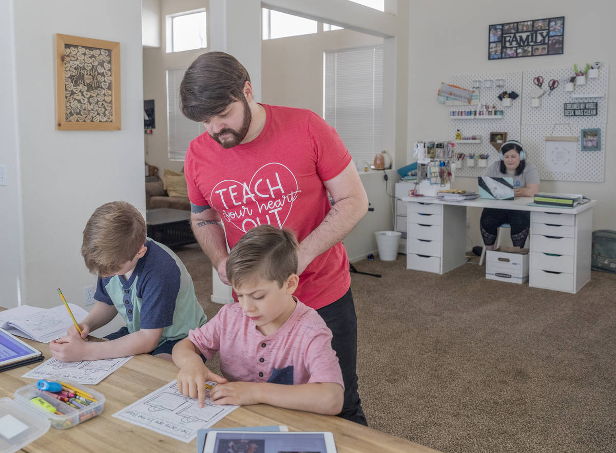 Twins Everett, left, and Atticus Mayville, 7, work on a school project as their mom, a middle s ...