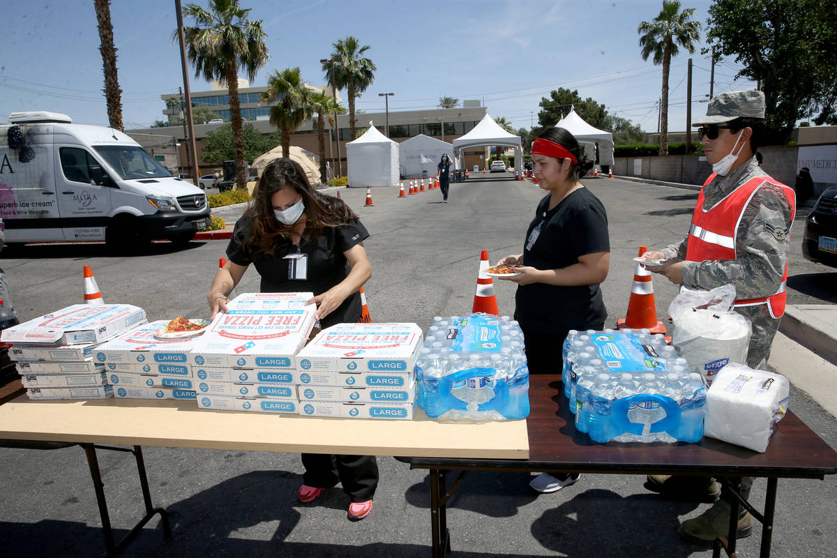 UNLV Medicine staff and Nevada National Guard members doing curbside COVID-19 testing, from lef ...