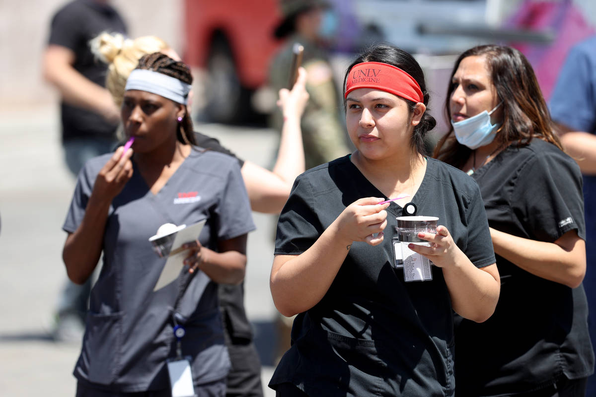 UNLV Medicine staff doing curbside COVID-19 testing, from left, certified medical assistants Be ...