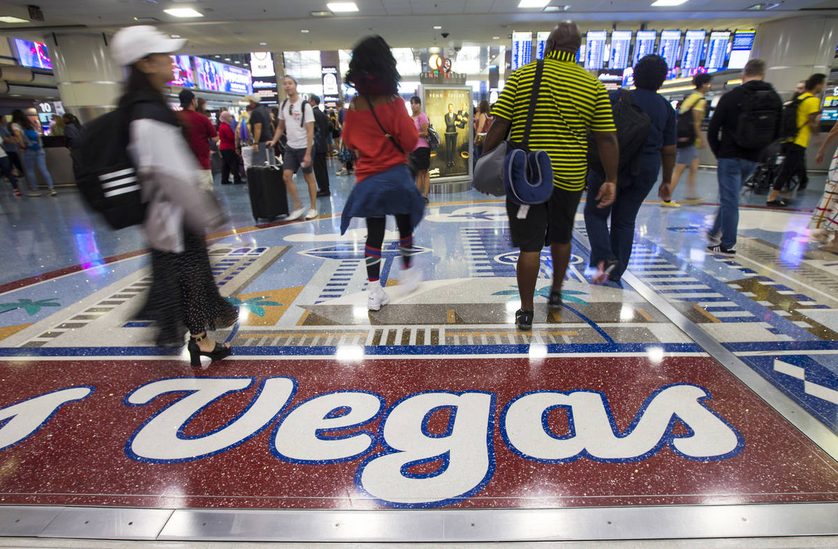 Passengers walk around the baggage claim area at McCarran International Airport ahead of the La ...