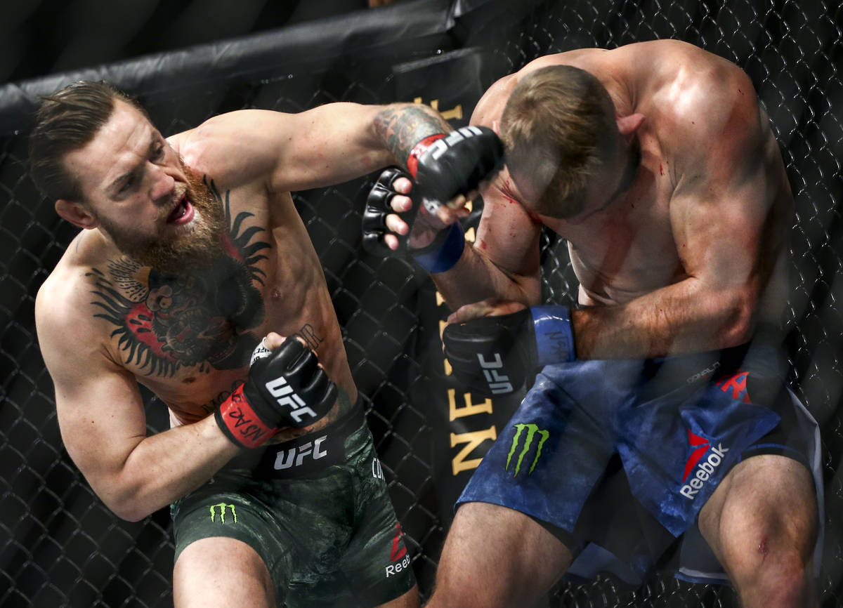 Conor McGregor, left, fights Donald "Cowboy" Cerrone during their welterweight bout a ...