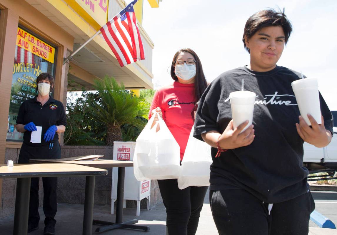 Amanda Sanchez, center, and her daughter Destiny Torres pick up their order from a curbside pic ...