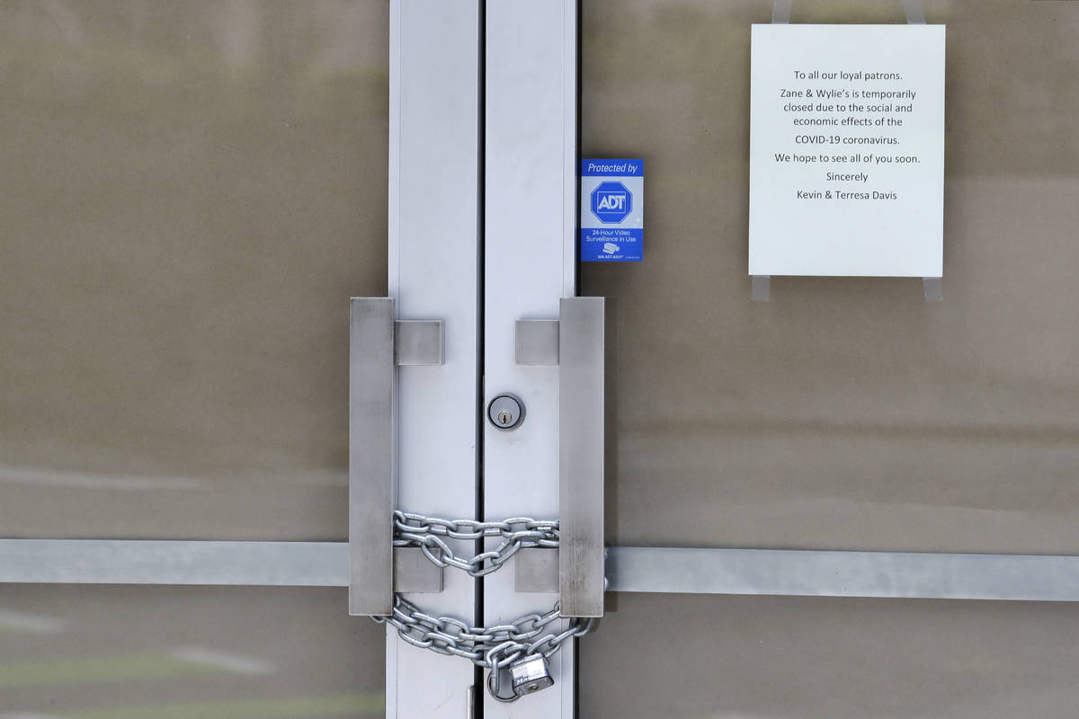 In this May 6, 2020 photo, a chain lock is shown on the entry doors to Zane + Wylie's Seattle S ...