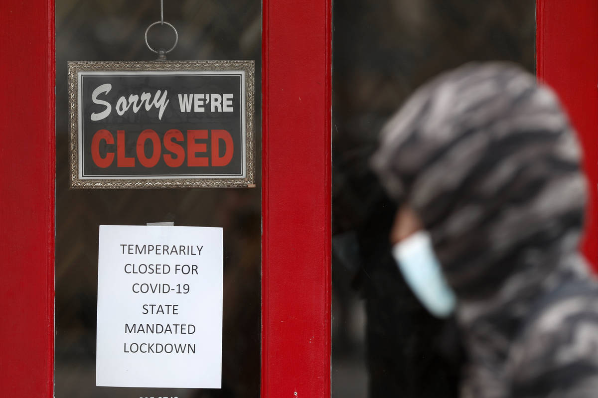 A pedestrian walks by The Framing Gallery, closed due to the COVID-19 pandemic, in Grosse Point ...