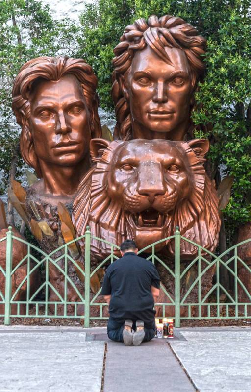 Zar Zanganeh, a friend of Roy Horn, prays next to candles he placed in front of a statue of Sie ...