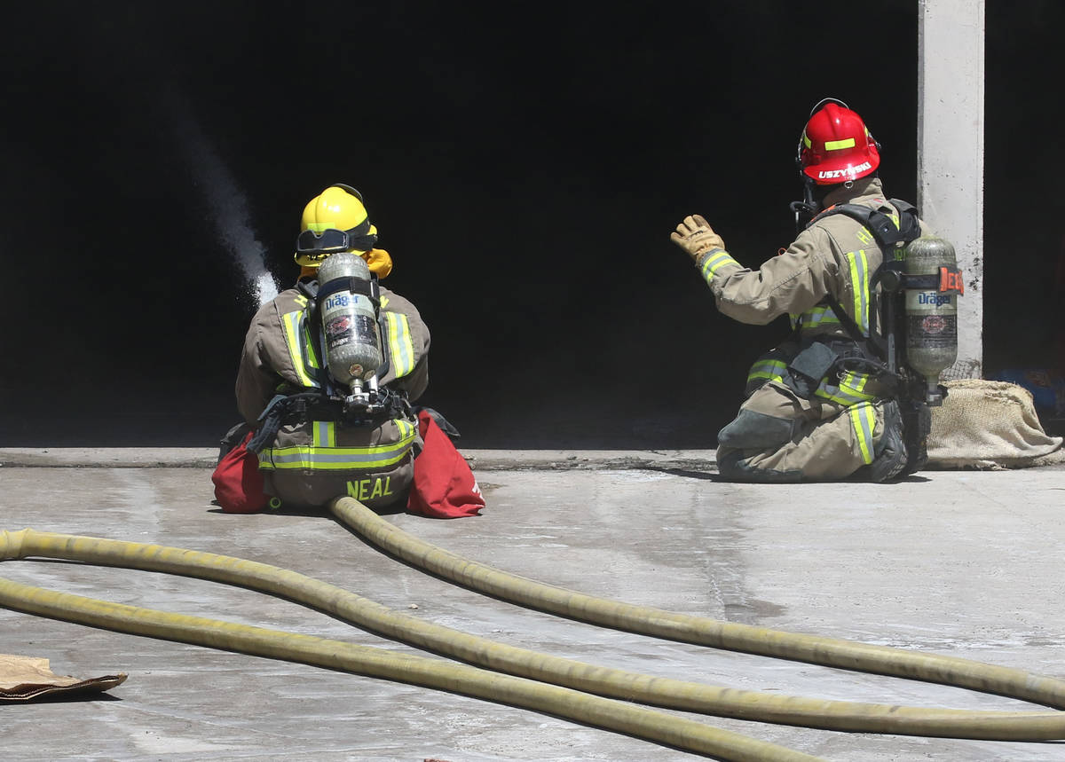 Henderson firefighters battle a fire in a storm drain that generated a large amount of smoke on ...