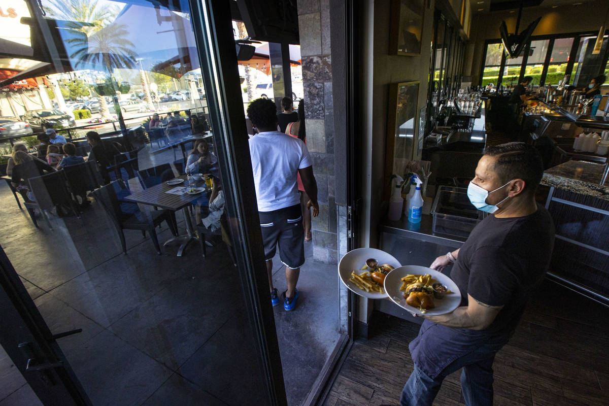 Rosendo Rodriguez brings food to patrons at Kona Grill in Boca Park as some restaurants open fo ...