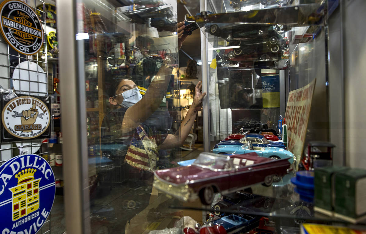 Seller Delilah Costello readies the items in one of her glass cases for sale within the Antique ...