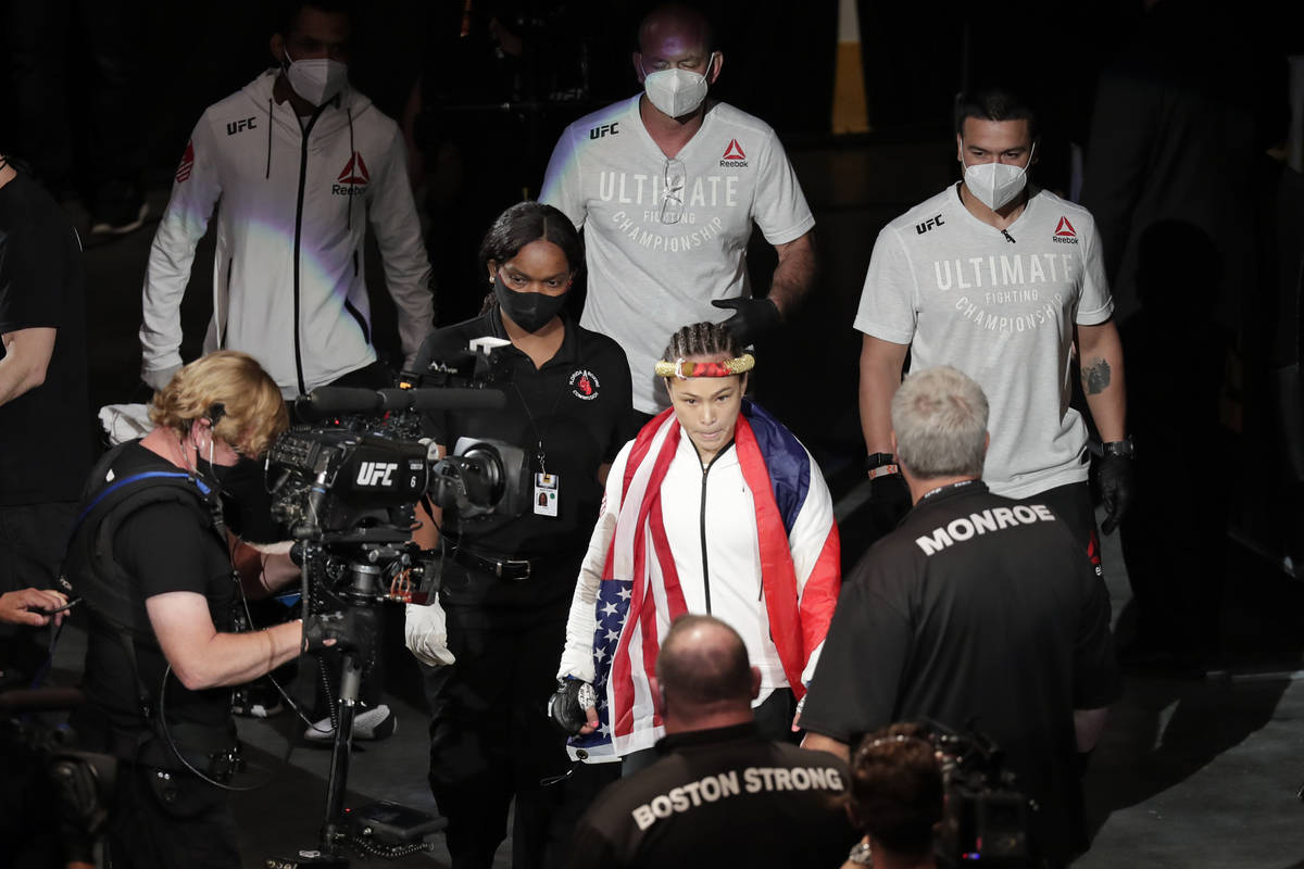 Michelle Waterson, center, enters the arena before her fight against Carla Esparaza at a UFC 24 ...