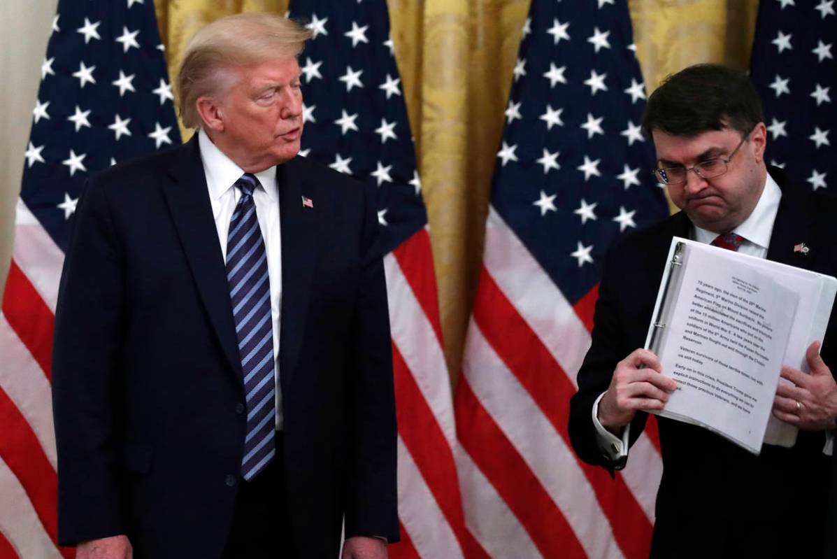 President Donald Trump watches as Veterans Affairs Secretary Robert Wilkie walks away after spe ...