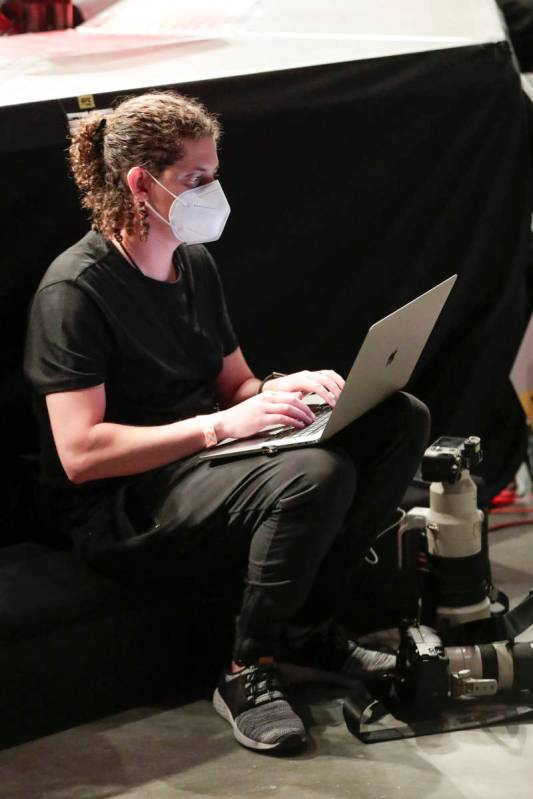 Wearing a mask, a photographer files photos during a UFC 249 mixed martial arts bout, Saturday, ...