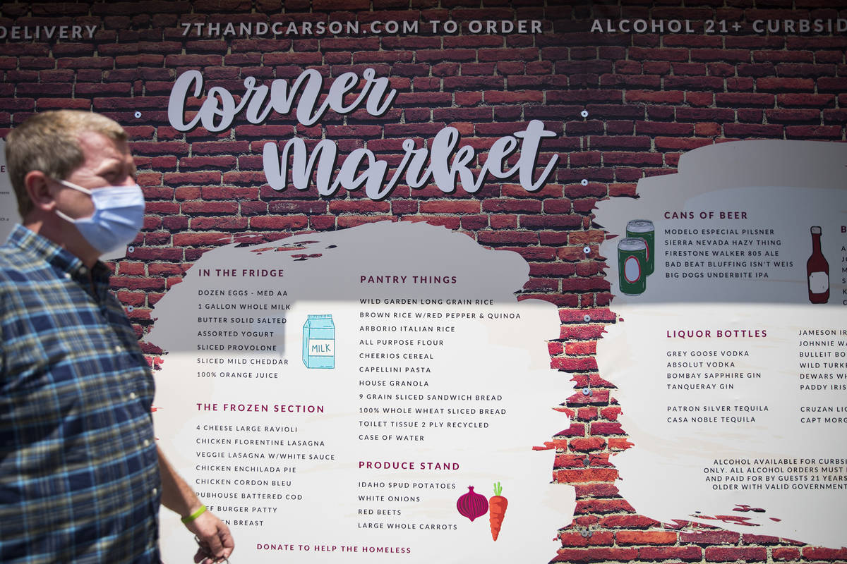 Owner Liam Dwyer walks past a giant menu at 7th & Carson in Las Vegas, Sunday, May 10, 2020 ...