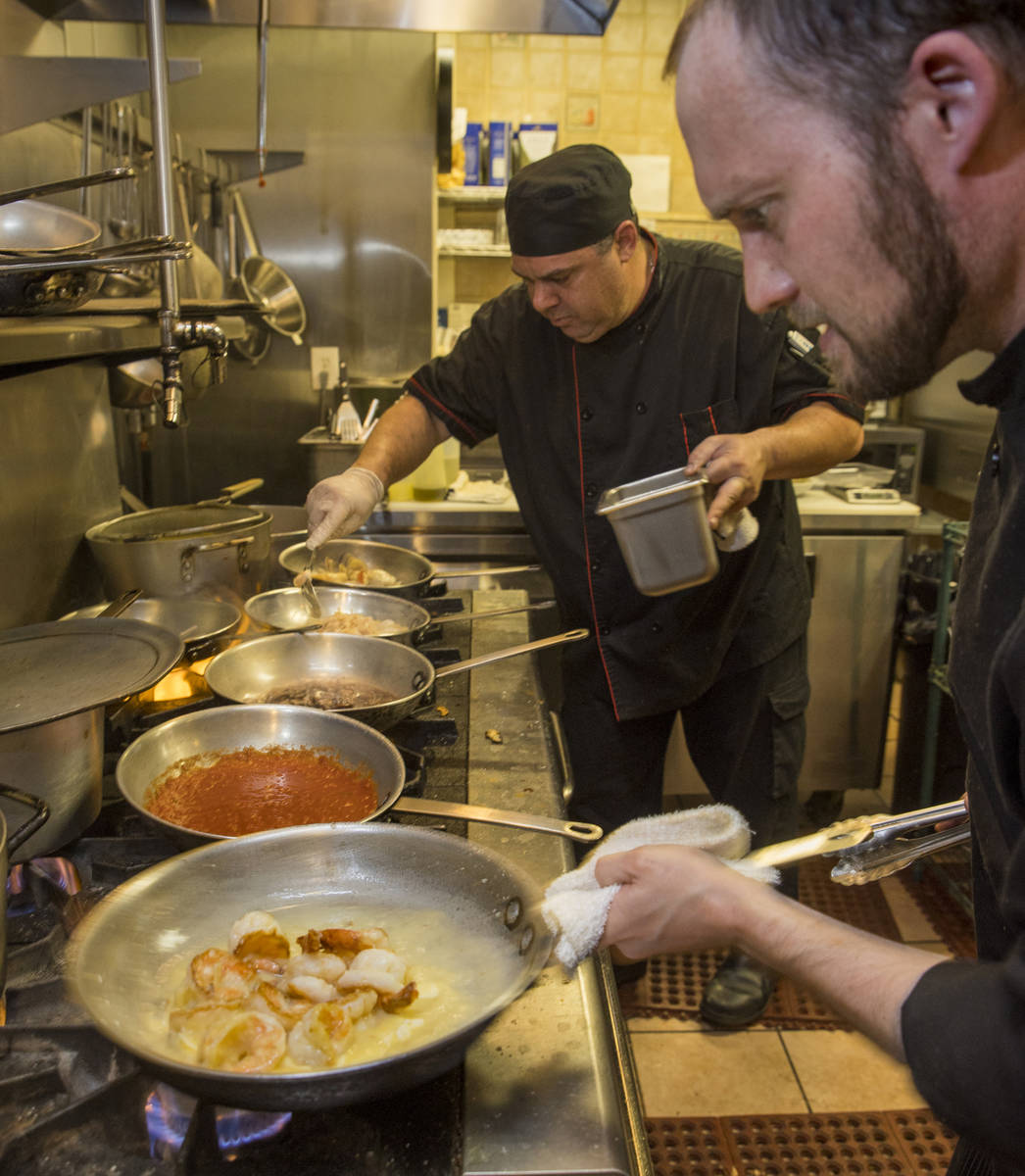 Chef de cuisine Michael Prout, right, and owner/head chef Dan Thompson prepare more dishes in t ...