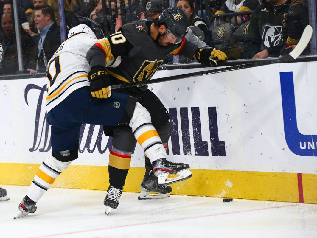 Buffalo Sabres' Henri Jokiharju (10) battles for the puck against Golden Knights' Chandler Step ...