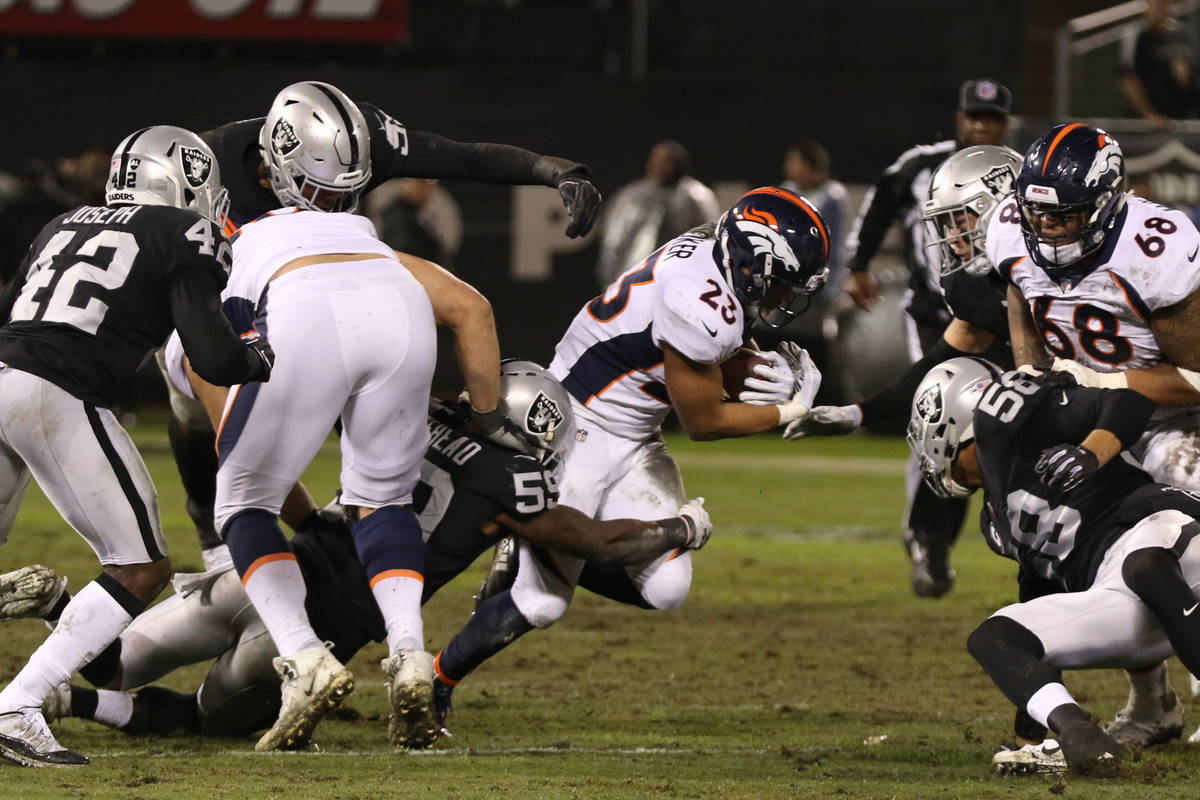 Denver Broncos running back Devontae Booker (23) runs with the football as Oakland Raiders outs ...