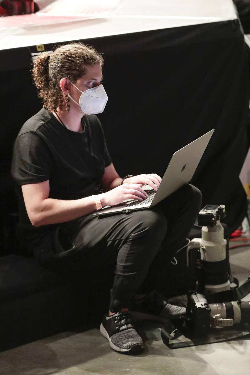 Wearing a mask, a photographer files photos during a UFC 249 mixed martial arts bout, Saturday, ...