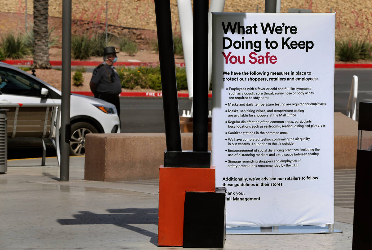 A security guard stands duty past one of the many customer information signs now installed thro ...