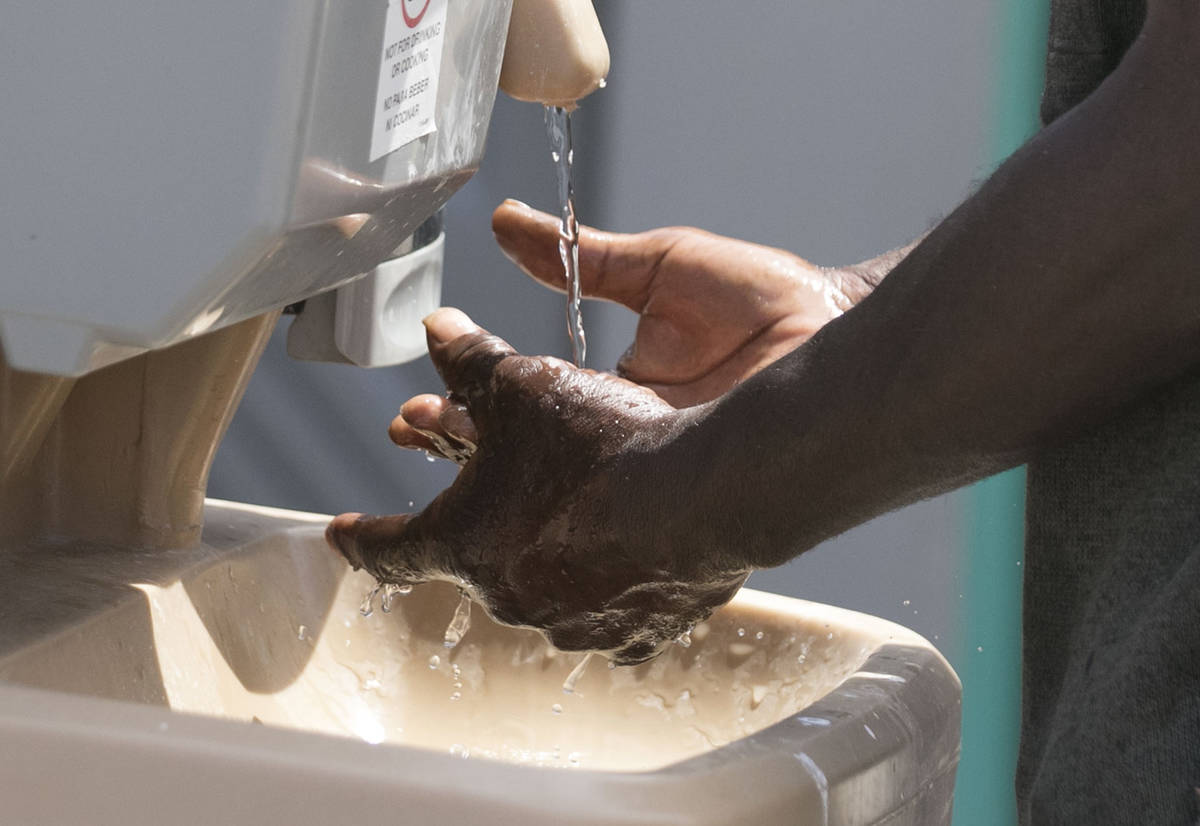 A client washes his hands at hand washing stations at The Courtyard Homeless Resource Center on ...