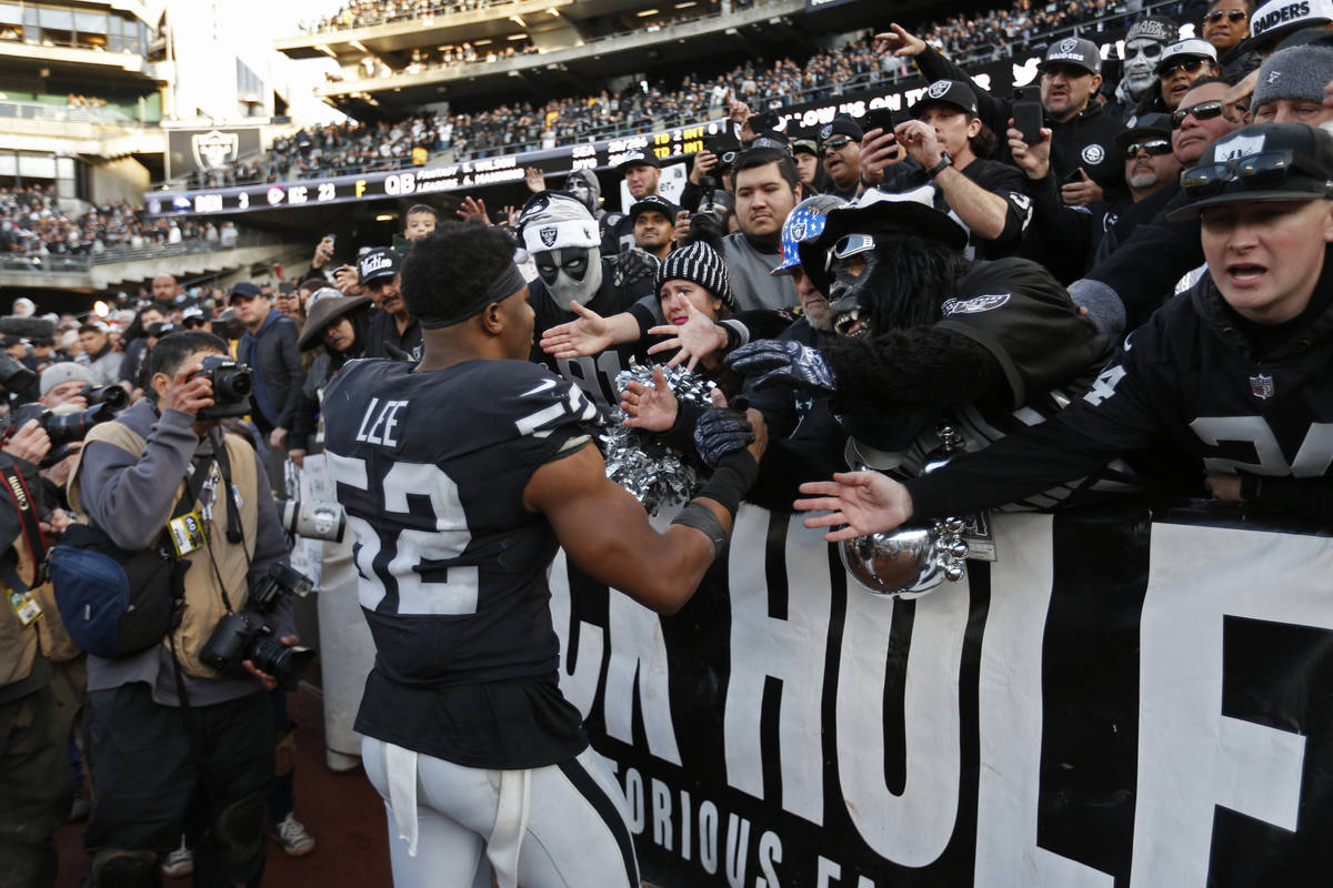 Oakland Raiders middle linebacker Marquel Lee (52) is greeted by fans in "The Black Hole&q ...