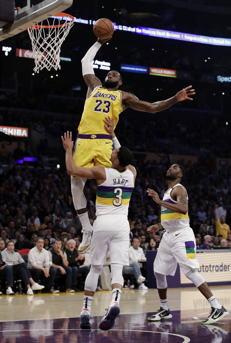 Los Angeles Lakers forward LeBron James (23) dunks over New Orleans Pelicans' Josh Hart (3) dur ...