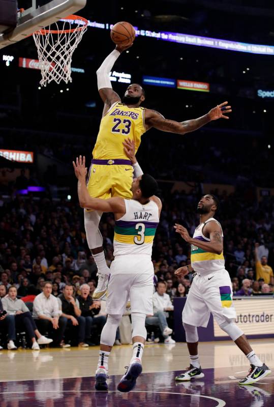 Los Angeles Lakers forward LeBron James (23) dunks over New Orleans Pelicans' Josh Hart (3) dur ...