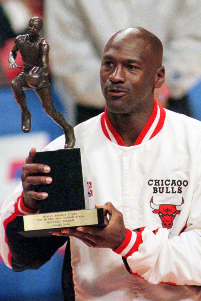 FILE - In this May 19, 1998, file photo, Chicago Bulls' Michael Jordan looks at the MVP award p ...