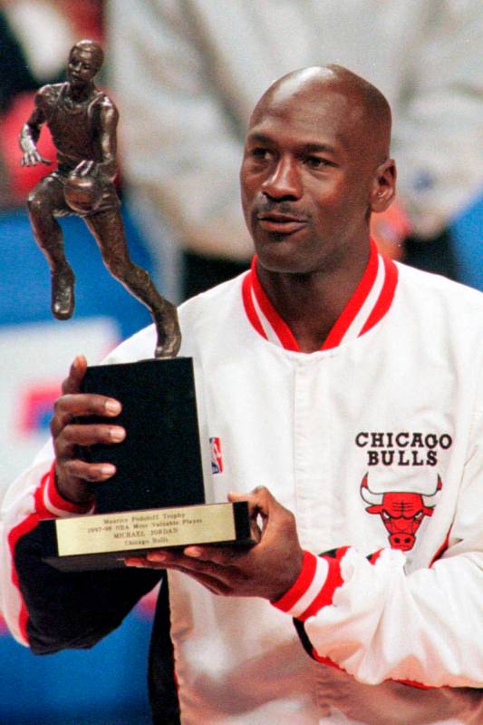 FILE - In this May 19, 1998, file photo, Chicago Bulls' Michael Jordan looks at the MVP award p ...