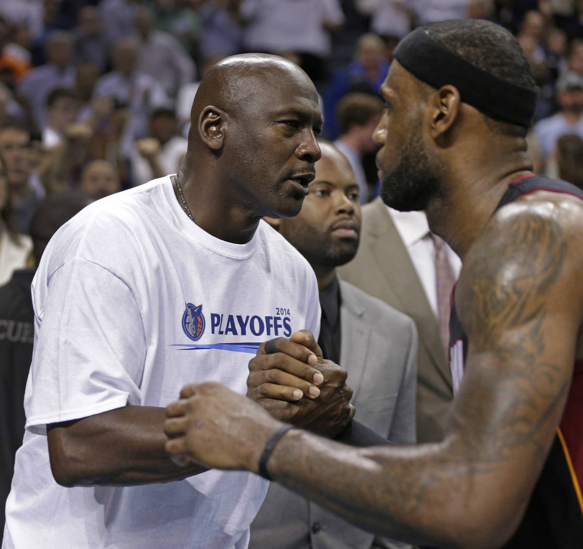 Charlotte Bobcats owner Michael Jordan, left, shakes hands with Miami Heat's LeBron James, righ ...