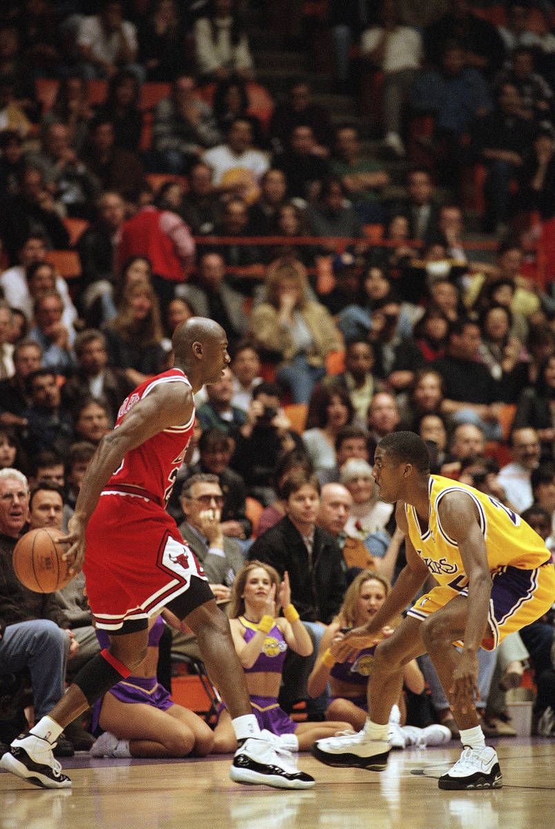 The Chicago Bulls' Michael Jordan, left, palms the ball as the Los Angeles Lakers? Eddie Jones ...