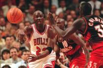 Chicago Bulls' Michael Jordan passes off around Atlanta Hawks' Mookie Blaylock (10) and Tyrone ...